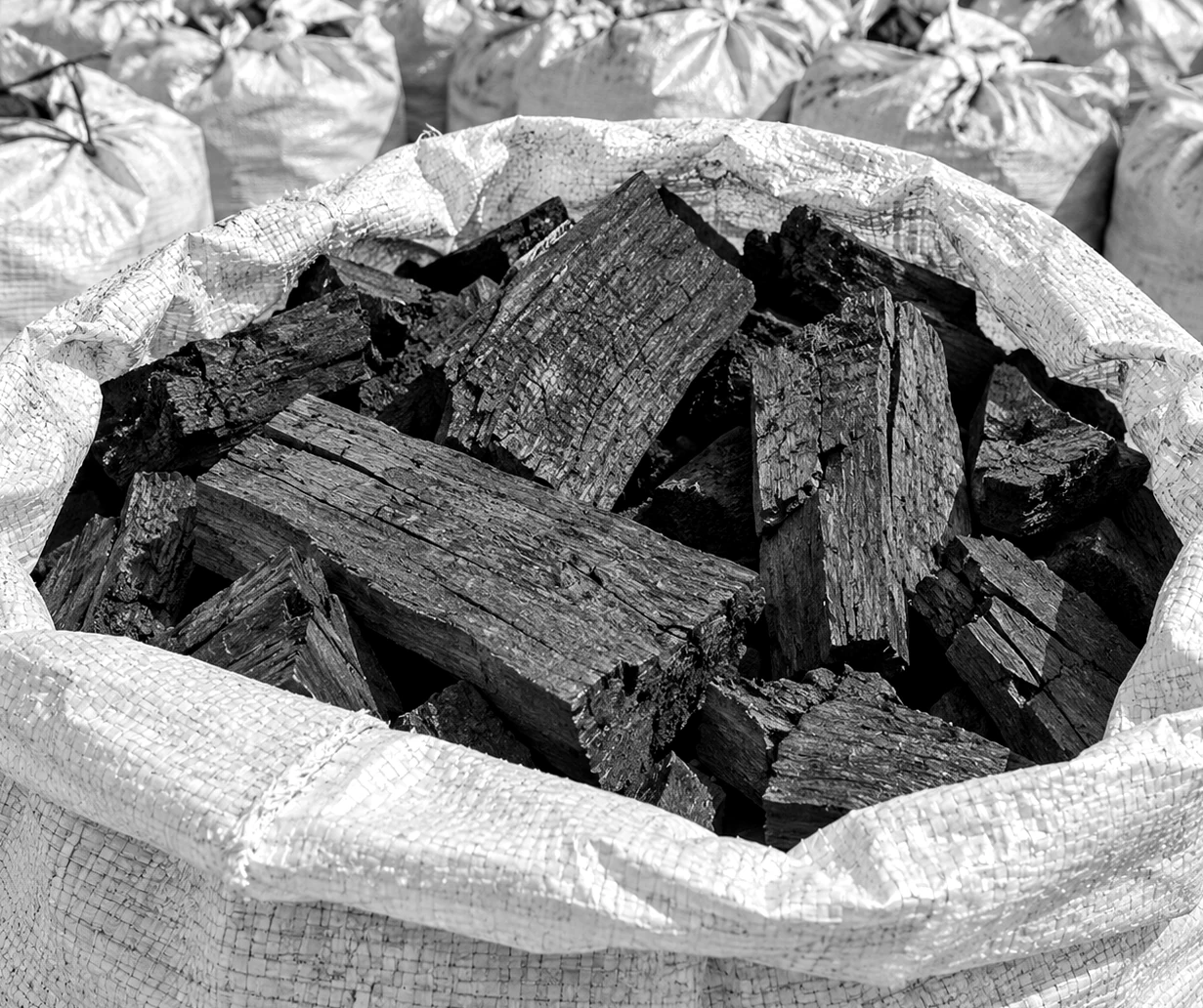 Saco de rafia abierto con trozos de carbón vegetal